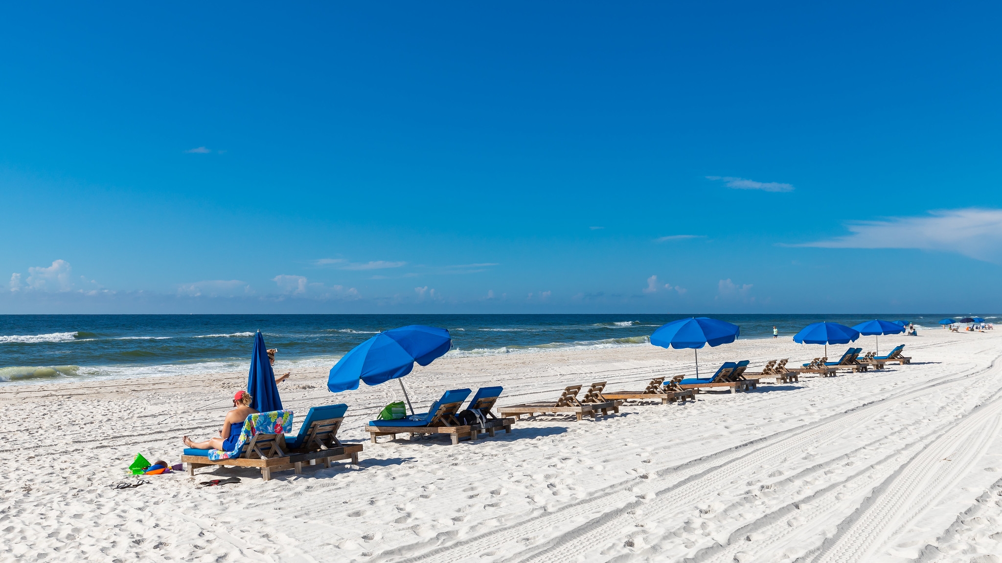 Beach chairs on a white-sand shoreline