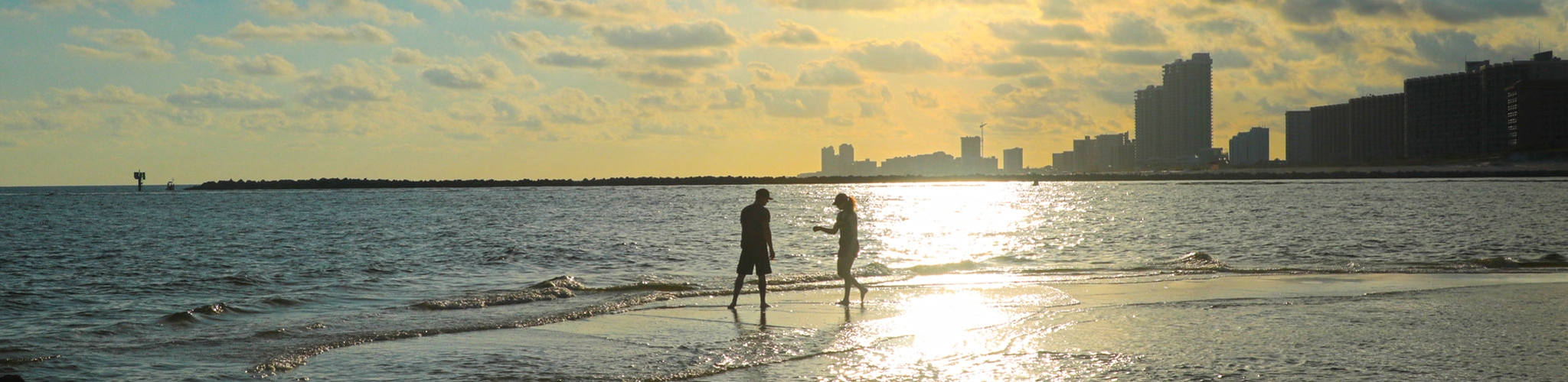 Visitors walking beside the water at sunset