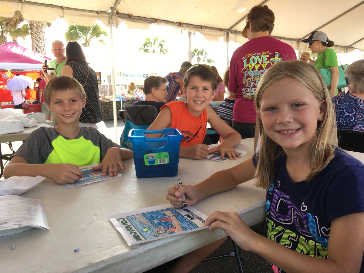 Children seated at a festival activity table