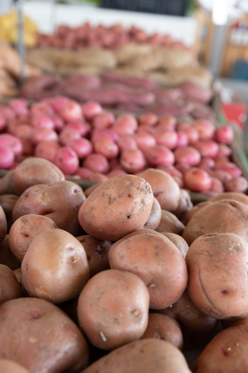 Fresh potatoes and red onions on display at a market