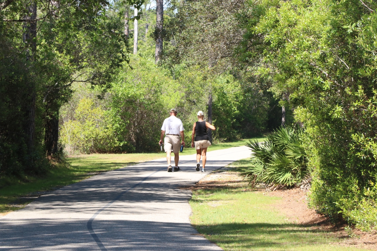 People walking on a paved Backcountry Trail path