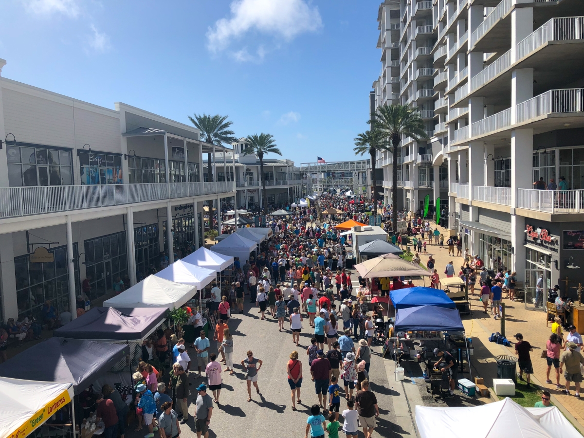 Crowds and vendor tents along The Wharf’s Main Street