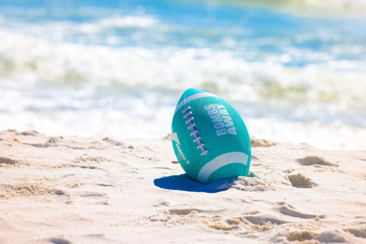 Football resting on the sand at the beach