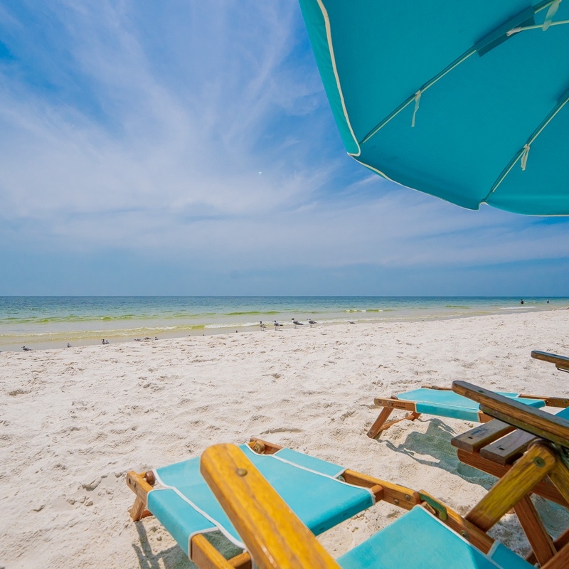 Beach chairs and an umbrella beside the Gulf