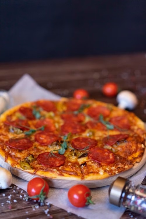 Pepperoni pizza with tomatoes and herbs