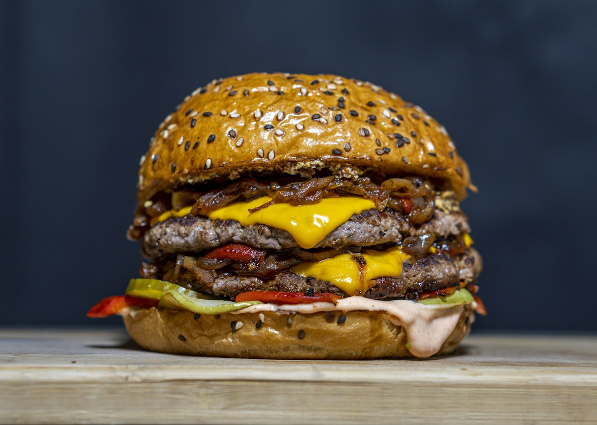 Cheeseburger with vegetables on a sesame bun